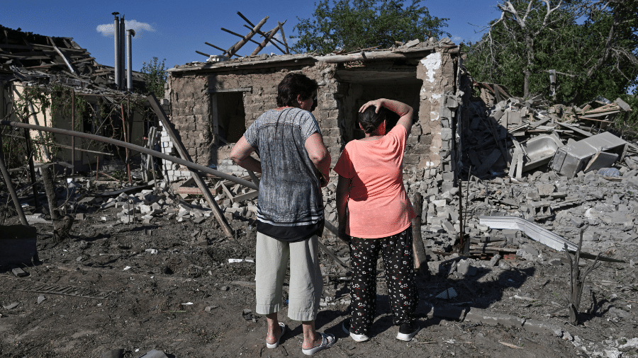 13.jul.26 - Mulheres observam casas danificadas por ataque aéreo russo em Zaporizhzhia, Ucrânia - undefined