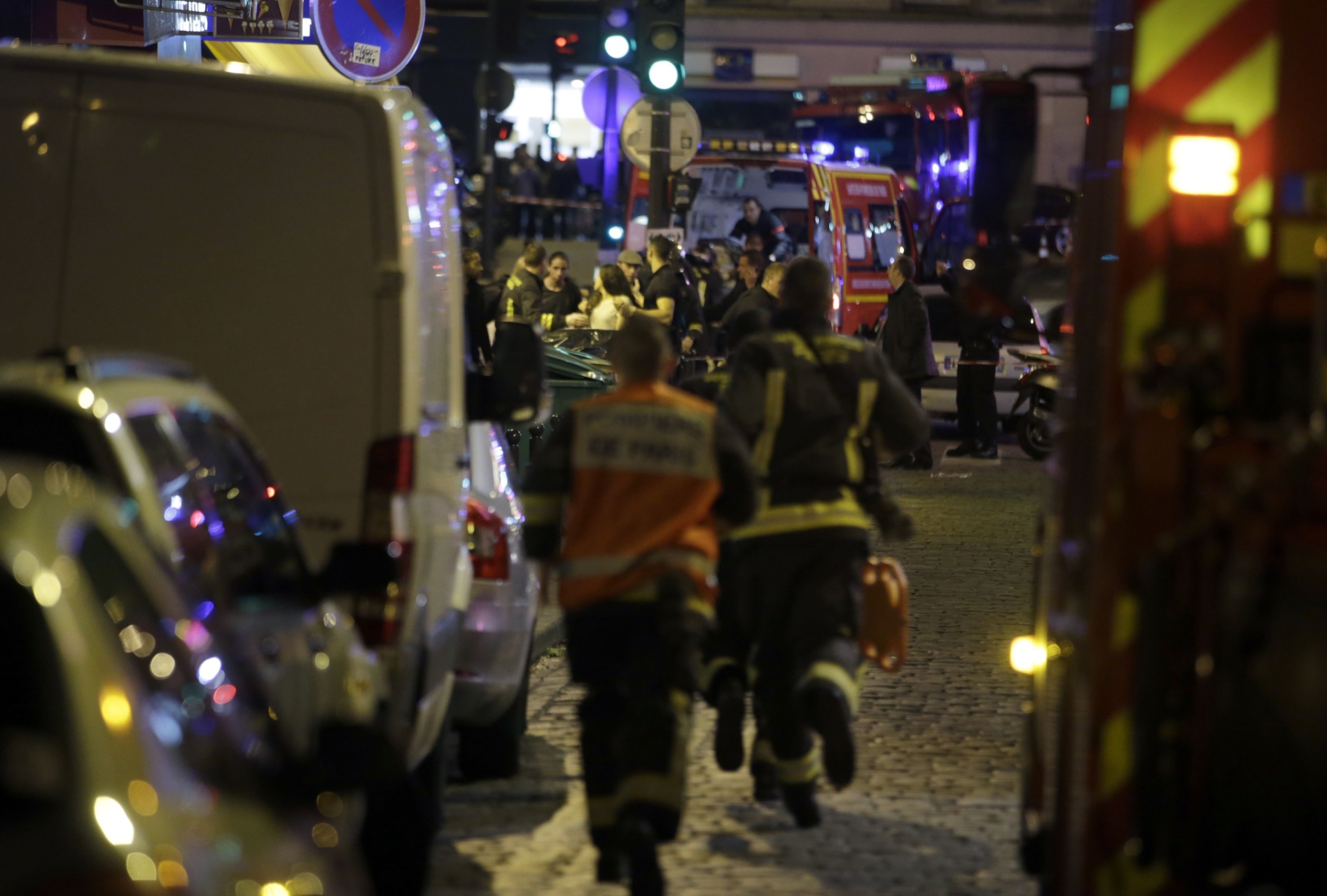 13.nov.2015 - Equipes de resgate correm em rua próxima ao local de um tiroteio em Paris, na França. Tiroteios e explosões aconteceram na noite desta sexta-feira (13) na capital francesa. A polícia relatou ao menos duas explosões nas proximidades do estádio Stade de France, onde o presidente francês, François Hollande, acompanhava um amistoso da seleção francesa - Kenzo Tribouillard/AFP