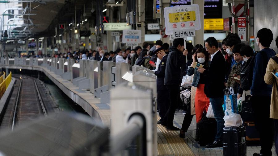 Passageiros esperam por trem em uma estação em Tóquio, no início do inédito feriado de 10 dias - Kazuhiro Nogi/AFP