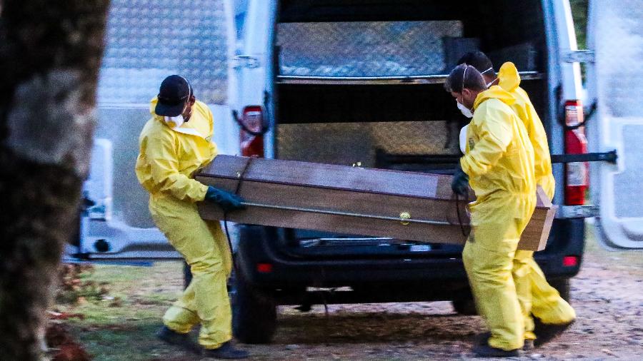 Homens carregam corpo de paciente morta por covid-19 no Cemitério Santo Antônio, em Sorocaba (SP) - Cadu Rolim - 6.abr.2020/Fotoarena/Estadão Conteúdo