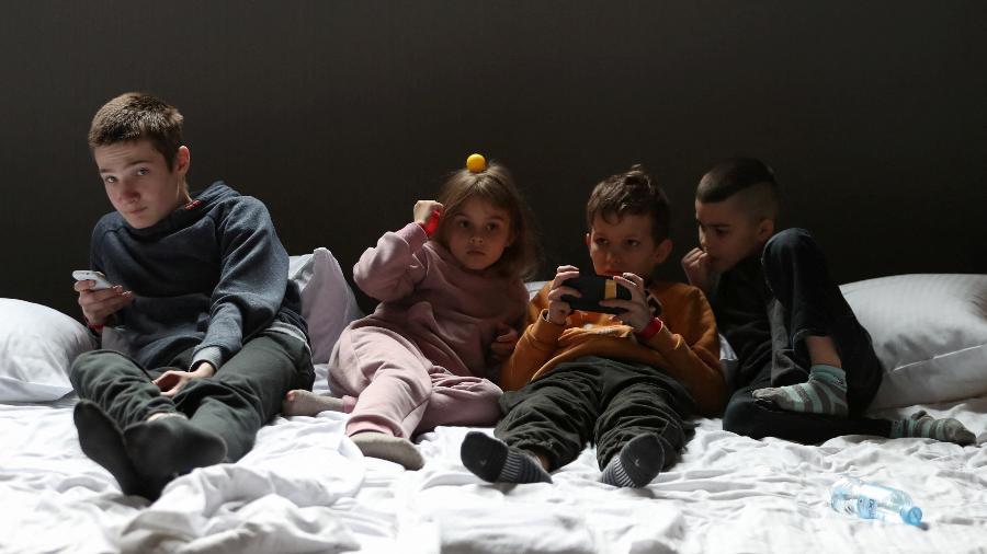 05.mar.22 - Crianças ucranianas, que viajaram com o transporte humanitário de orfanatos após a invasão russa, sentam em um colchão no Hotel Ossa, perto de Rawa Mazowiecka, Polônia
