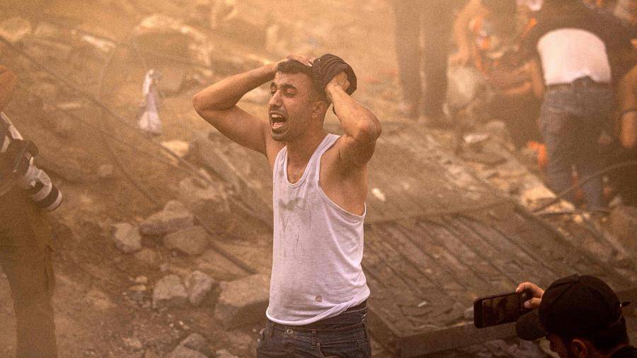 Palestino se desespera em destroços de prédio em Khan Yunis, destruído na guerra entre Israel e o grupo extremista Hamas