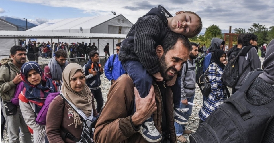 28.set.2015 - Migrantes fazem fila enquanto aguardam para pegar um trem no campo de registro, que fica na fronteira entre Macedônia e Grécia