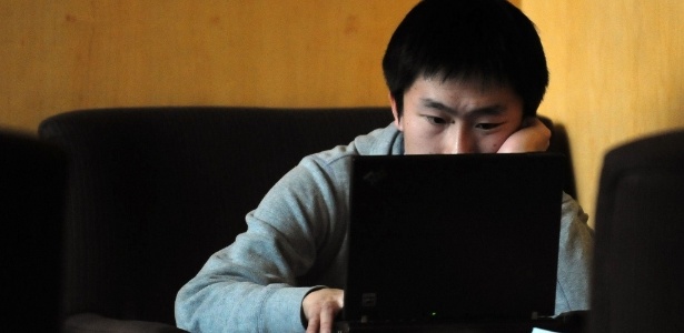 Jovem navega na web em um café com acesso à internet em Pequim, na China - Frederic J. Brown/AFP