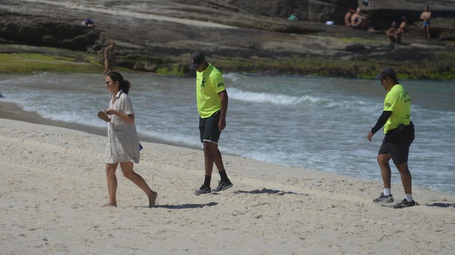 Policiais militares abordam mulher que desrespeitou bloqueio em praia na zona sul do Rio - ERBS JR./FRAMEPHOTO/ ESTADÃO CONTEÚDO