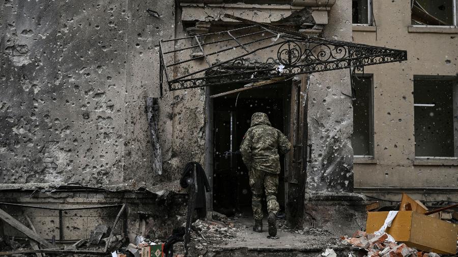 27.mar.2022 - Soldado ucraniano entra em quartel-geral destruído de Kharkiv, na Ucrânia - Aris Messinis / AFP