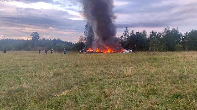 Destroços de avião pegando fogo no vilarejo de Kuzhenkino, na região de Tver, Rússia; governo diz que líder mercenário estava entre os passageiros