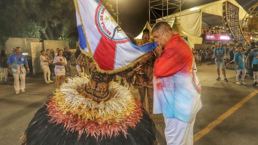 Milton Leite beija a bandeira da escola de samba Estrela do 3º Milênio