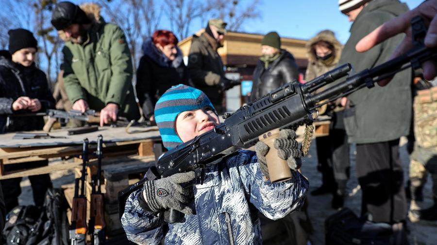 13.fev.2022 - Criança segura arma durante treinamento militar para civis na Ucrânia - UMIT BEKTAS/REUTERS