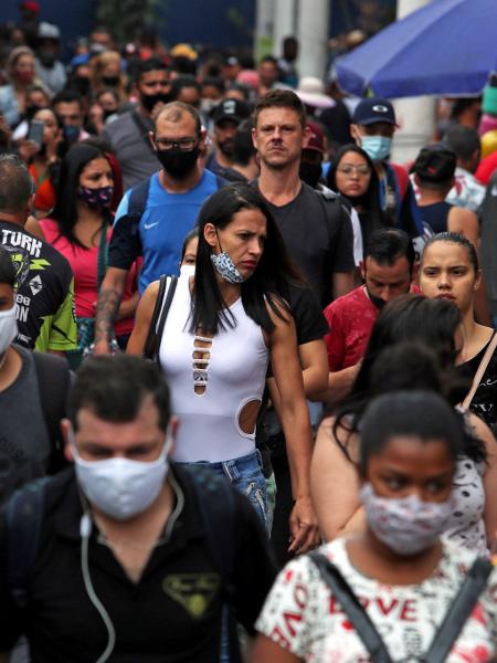 Pessoas com máscara de proteção caminham em rua de comércio popular em São Paulo - Amanda Perobelli/Reuters
