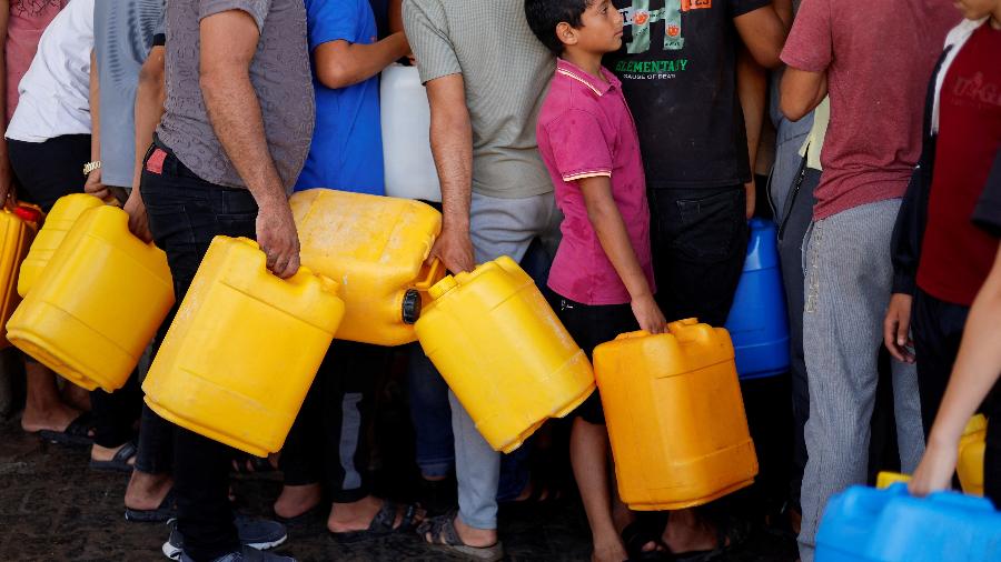 Palestinos fazem fila para pegar água em meio a cerco de Israel à Faixa de Gaza
