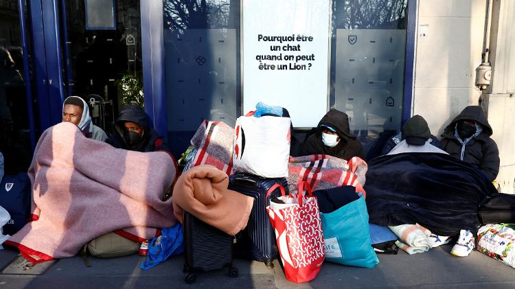 18.mar.2025 - Imigrantes sentados na rua após a polícia retirá-los do teatro Gaîté Lyrique 18.mar.2025 - Imigrantes sentados na rua após a polícia retirá-los do teatro Gaîté Lyrique