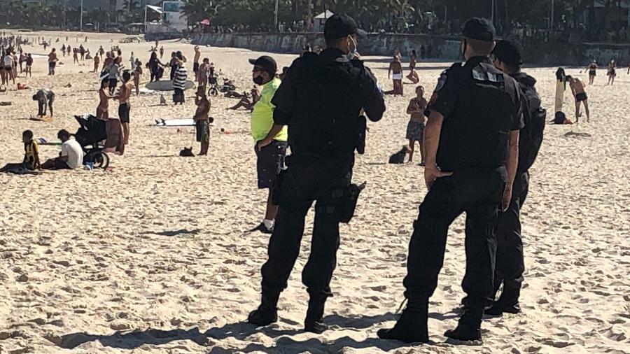 18.jul.2020 - Policiais militares fazem abordagens a pessoas sentadas nas areias da praia de Ipanema, na zona sul do Rio de Janeiro - Herculano Barreto Filho/UOL
