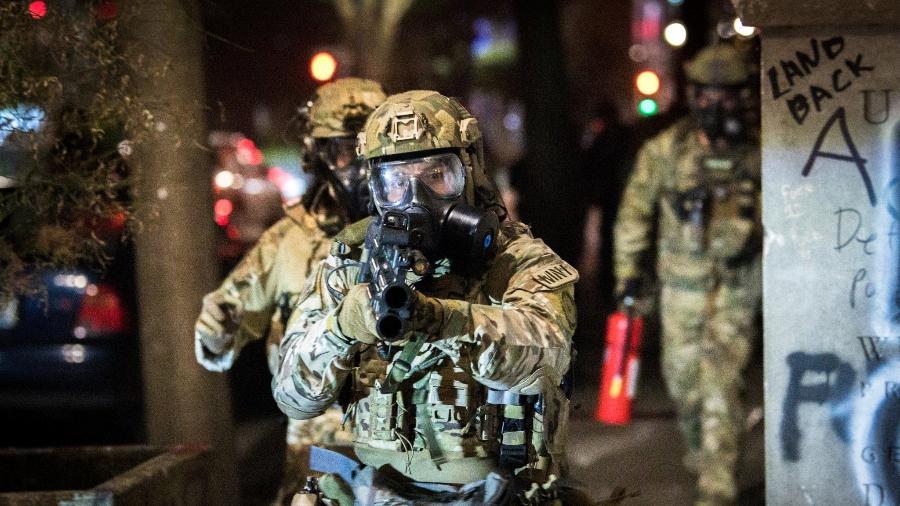 Policial aponta arma para fotógrafo durante protesto em Portland, nos EUA - Reprodução/Twitter/MathieuLRolland