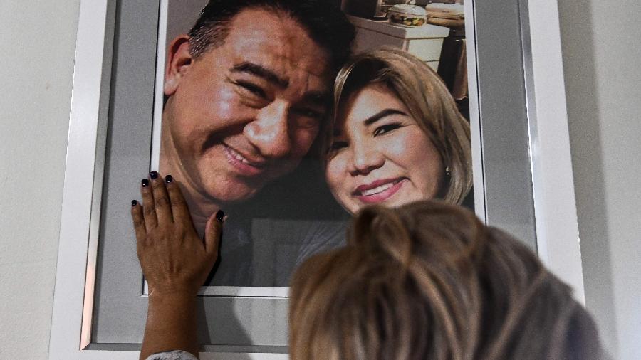 Glenda Yaneth Amaya Gamez toca foto de seu falecido marido, Francisco Amaya Gamez - CHANDAN KHANNA / AFP
