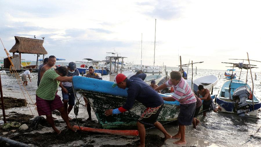26.out.2020 - Pescadores retiram barco de água por causa da aproximação do furacão Zeta, em Cancún, no México - Jorge Delgado/Reuters
