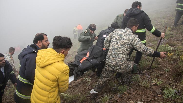 Equipe de resgate carrega um corpo após a queda de um helicóptero que transportava o presidente do Irã, Ebrahim Raisi, em Varzaqan, província do Azerbaijão Oriental, Irã, 20 de maio de 2024