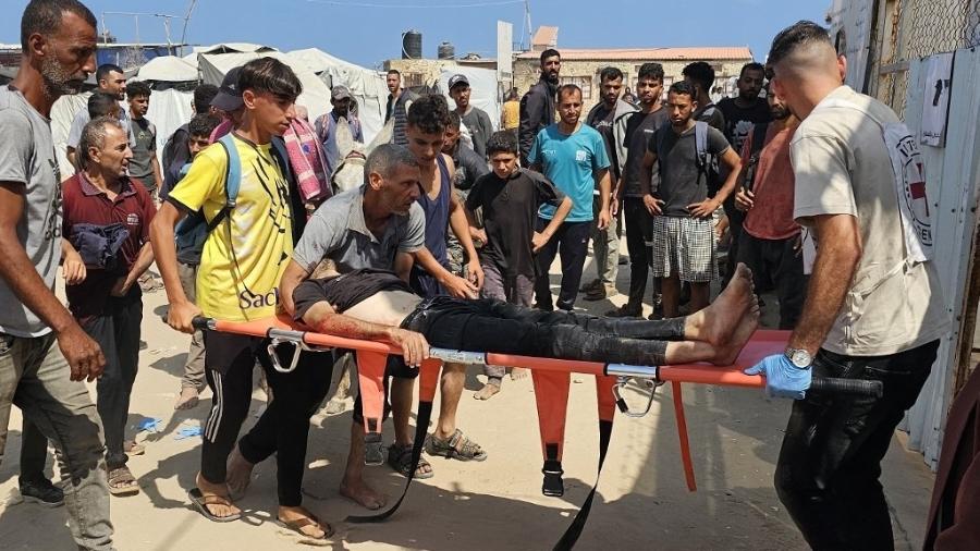 16.jun.2025 - Palestinos carregam um homem ferido enquanto aguardava para receber ajuda em Rafah 16.jun.2025 - Palestinos carregam um homem ferido enquanto aguardava para receber ajuda em Rafah