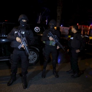 Policiais da Tunísia inspecionam local onde ônibus que transportava guardas presidenciais explodiu em Túnis