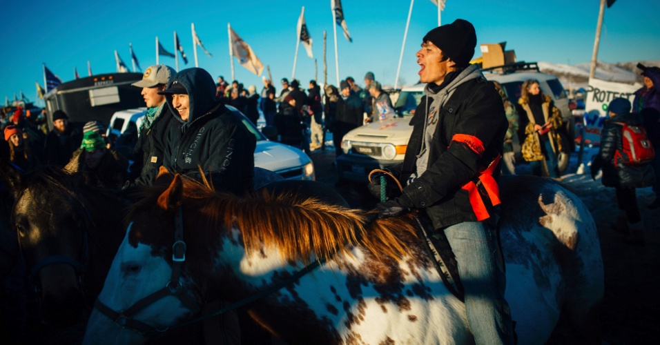 DEZEMBRO: PROTESTO INDÍGENA EMPERRA CONSTRUÇÃO DE OLEODUTO - Em 4 de dezembro, o manifestante comemorou o anúncio, feito pelo Exército dos EUA, de alteração da rota do oleoduto Dakota, depois de um mês de enfrentamentos entre a tribo sioux Standing Rock e o Corpo de Engenheiros do Exército dos EUA. Segundo a tribo e seus apoiadores, a obra atravessaria terras ancestrais sagradas e passaria sob o rio Missouri, podendo assim, em caso de vazamento, contaminar a principal fonte de água potável da reserva indígena. Porém, uma vez que o presidente eleito Donald Trump defende a conclusão do projeto, a liderança tribal teme que a decisão seja revertida