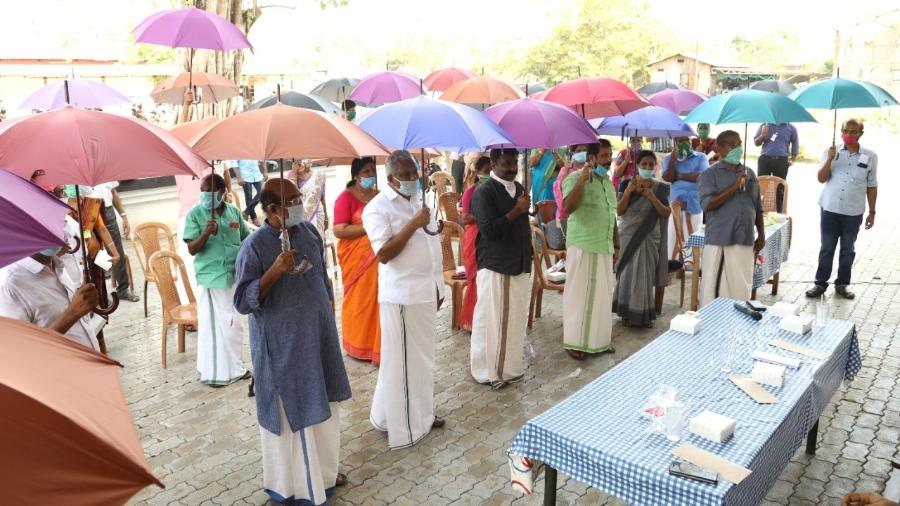 Moradores da vila de  Thannermukkom, em Kerala, na Índia. O governo distribuiu guarda-chuvas para ajudar a população a manter o distanciamento nas ruas - Divulgação