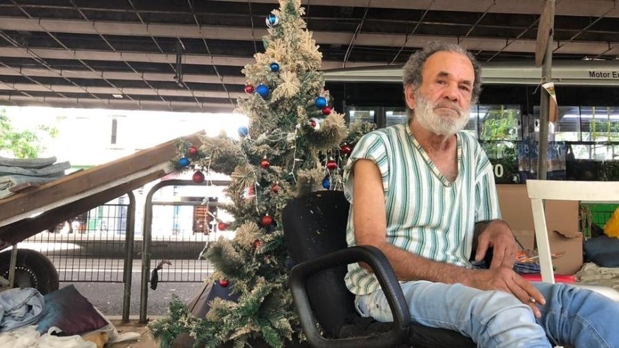 O carroceiro Ubiratan Cipriano e, ao fundo, sua árvore de Natal embaixo do Minhocão - LEANDRO MACHADO/BBC