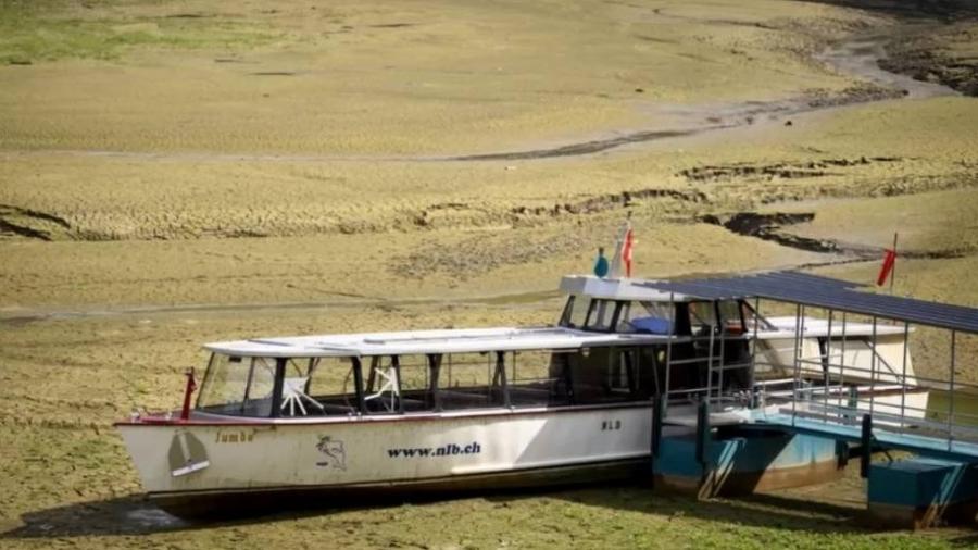 Seca está produzindo cenas como esta de um barco encalhado na lama da margem do Lago franco-suíço Brenets ? agora seco - EPA