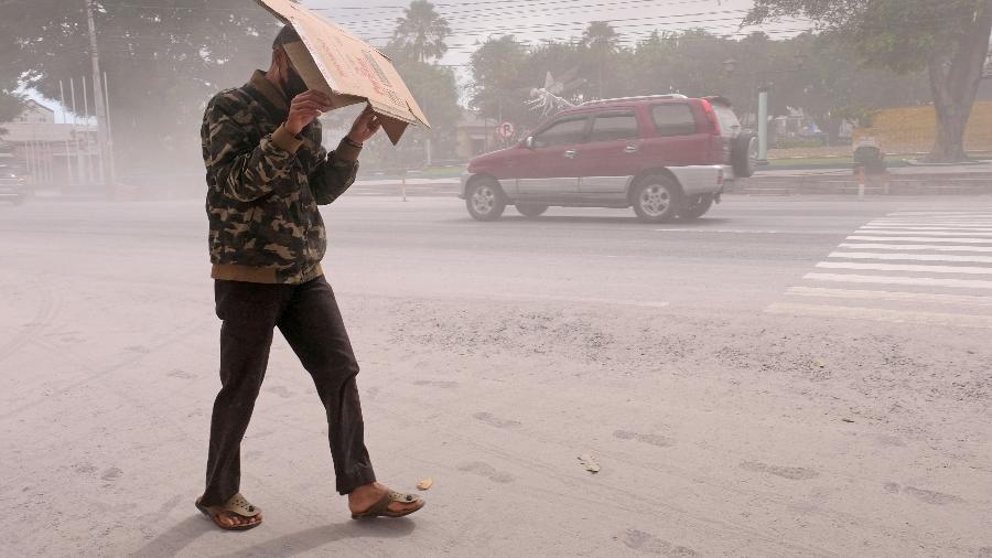 11.mar.23 - Um homem usa papelão para se proteger das cinzas da erupção do vulcão Monte Merapi, na Indonésia, em Magelang, província de Java Central, Indonésia - ANTARA FOTO/via REUTERS