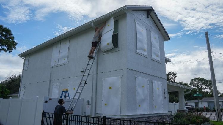 Moradores colocam tapumes em portas e janelas na véspera da chegada do furacão Milton na Flórida, nos Estados Unidos