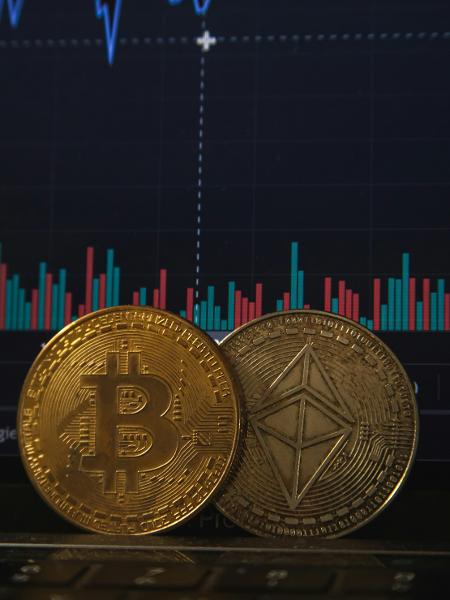 Representação de bitcoin junto a terminal de cotações financeiras - Pierre Borthiry/Unsplash