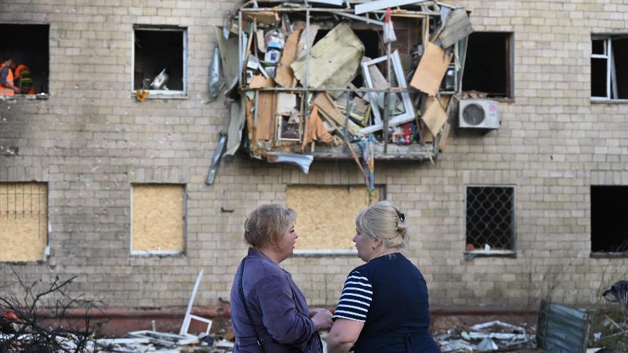 Mulheres perto de um prédio residencial danificado após um ataque de drone russo em Kharkiv - Sergey Bobok/AFP - 11/06/2025
