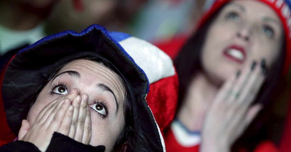 30.jun.2015 - Torcedores chilenos assistem à partida de futebol contra o Peru, em telão na cidade de Santiago, no Chile