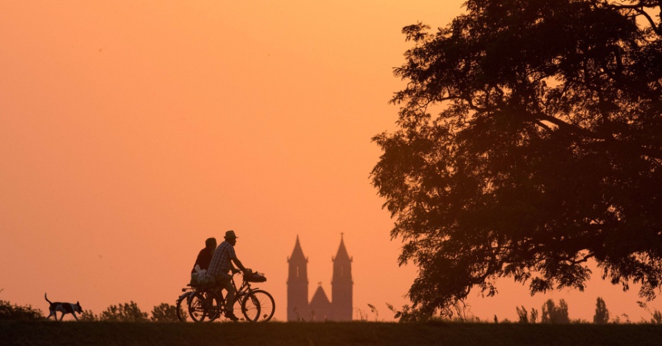 14.ago.2015 - Dois ciclistas e um cachorro caminham por uma aldeia em Magdeburg, na Alemanha