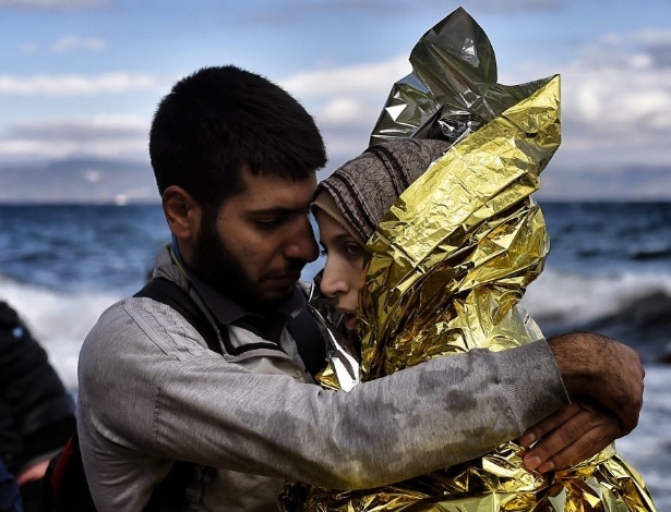 30.set.2015 - Refugiados se abraçam ao conseguir chegar na ilha grega de Lesbos, após atravessar o mar Egeu saindo da Turquia