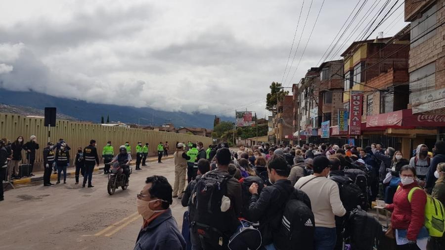 Em frente ao aeroporto vigiado pela polícia em Cusco, turistas brasileiros aguardam ser chamados para embarcar em voo com destino ao Brasil - Luciana Sarmento/UOL