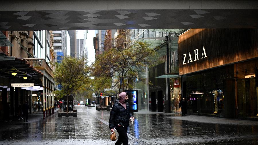 28.jun.2021 - Homem caminha por uma área comercial tranquila no distrito comercial central de Sydney, durante lockdown para conter surto da variante Delta do coronavírus  - Saeed Khan/AFP