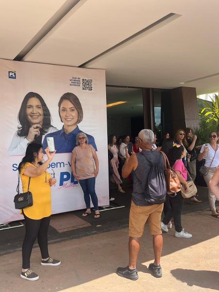 Apoiadores tiram foto com banner com a foto da ex-primeira-dama Michelle Bolsonaro durante evento do PL Mulher, em Brasília