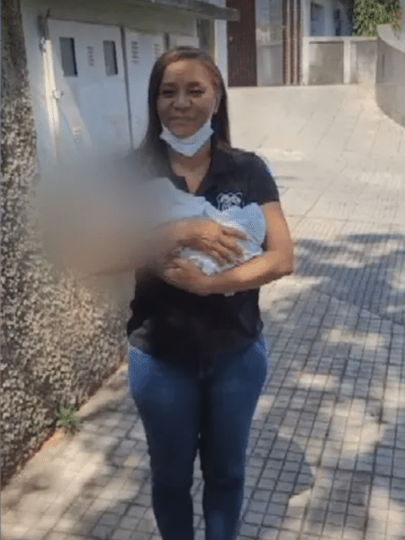A conselheira Alba Dourado segura bebê abandonado pela mãe após internação na UTI 