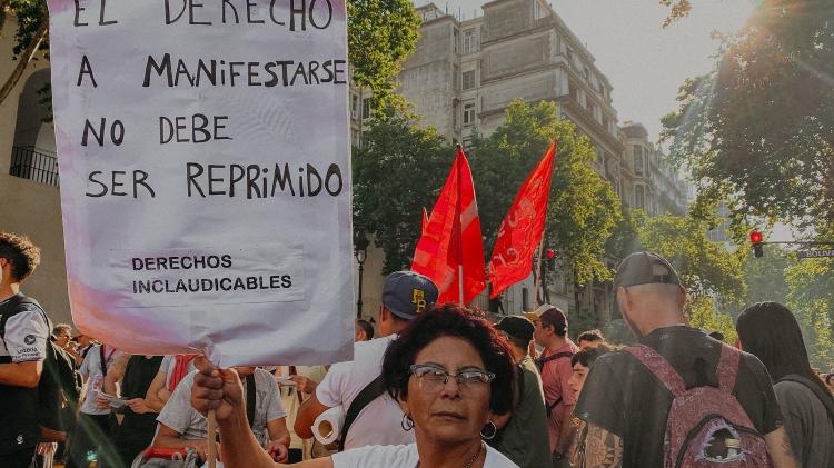 Mulher protesta com cartaz contra governo de Javier Milei na Argentina