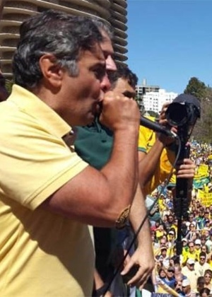 O senador Aécio Neves (PSDB) discursa para multidão em ato contra o governo de Dilma Rousseff na praça da Liberdade, em Belo Horizonte, neste domingo (16) - Reprodução/@Cris_duh_123/Twitter