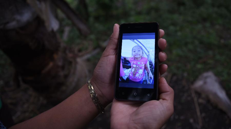 Familiar mostra, na tela de um celular, foto da garotinha Jakelin Amei Rosmery Caal, morta aos sete anos em um hospital do Texas dois dias depois de ter sido levada por agentes de fronteira norte-americanos no Novo México - Johan Ordonez/AFP