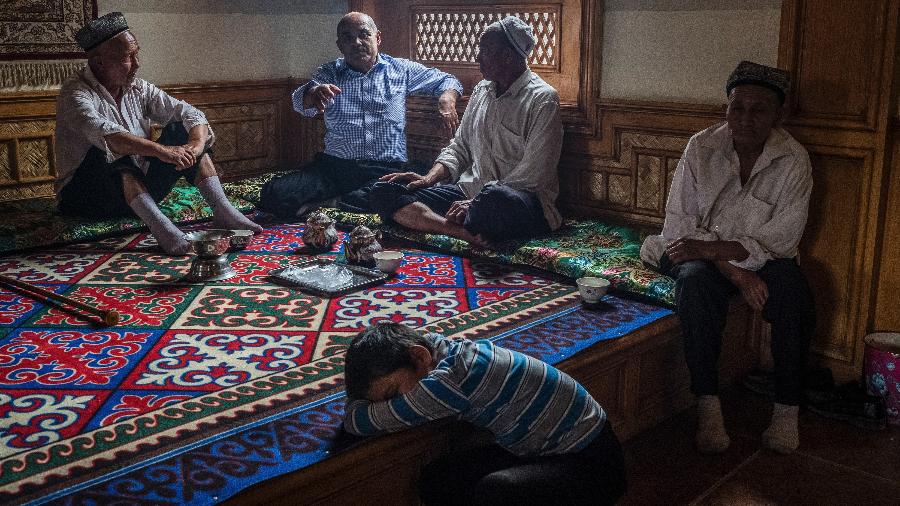 Homens da etnia uigur conversam em uma casa de chá, ao sul de Xinjiang, na China - Bryan Denton/The New York Times