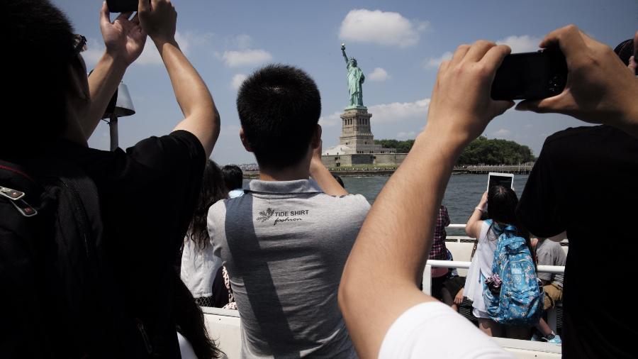 Turistas chineses fotografam a Estátua da Liberdade, em Nova York - Ángel Franco/The New York Times