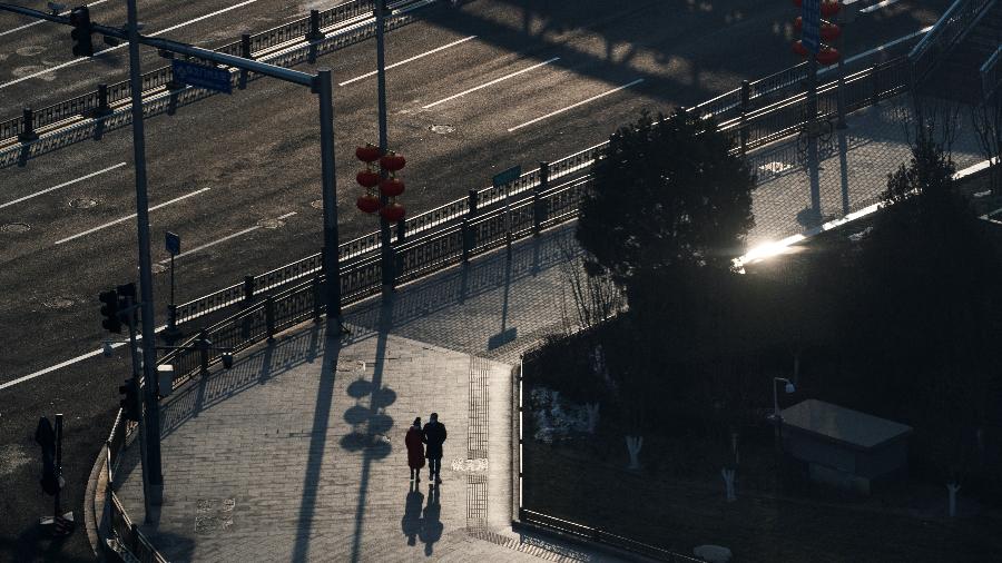 25.jan.2020 - Pessoas usam máscaras enquanto caminham por rua vazia no centro de Pequim - Thomas Peter/Reuters