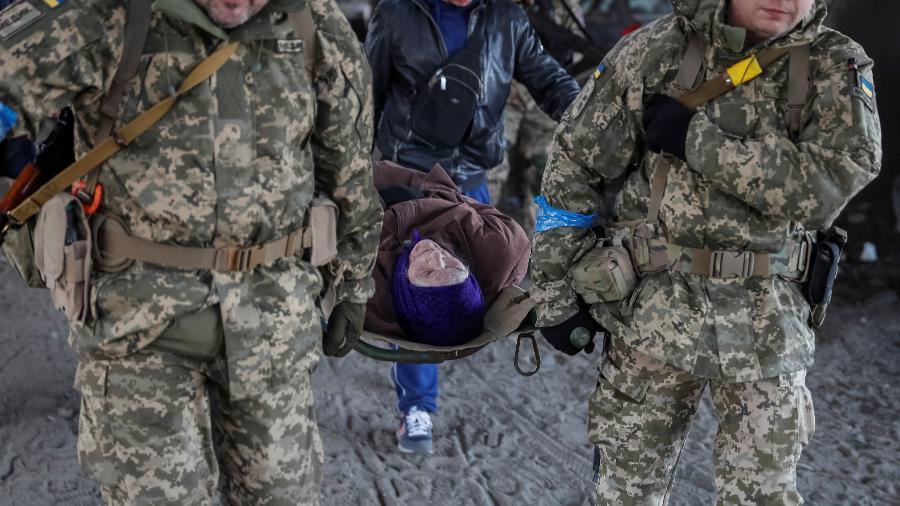 As imagens da guerra: idosos são transportados em macas de Irpin, na Ucrânia - REUTERS/Gleb Garanich