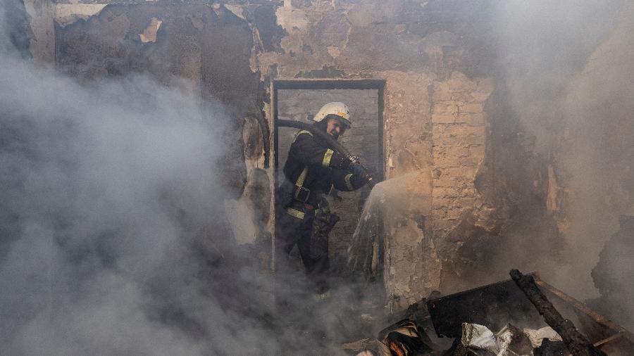 Bombeiro atua em distrito residencial danificado por disparos de atilharia russa em Kiev, na Ucrânia - Marko Djurica/Reuters