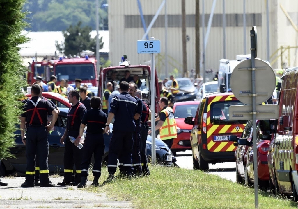 26.jun.2015 - Forças de segurança e de emergência se reúnem na entrada de usina em Saint-Quentin-Fallavier, próximo a Lyon, na França. Segundo autoridades, houve uma explosão no local após a entrada de um ou mais indivíduos. Foram encontrados uma bandeira com inscrições em árabe e um corpo decapitado - Philippe Desmaze/AFP