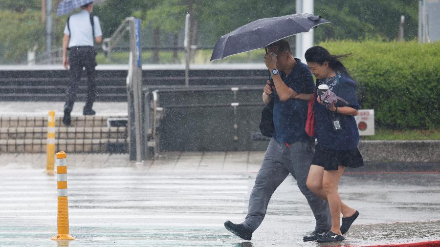 Pessoas usam guarda-chuvas do lado de fora do Aeroporto Taipei Songshan enquanto o tufão Gaemi se aproxima em Taipei, Taiwan, 24 de julho de 2024 - Carlos Garcia Rawlins/REUTERS