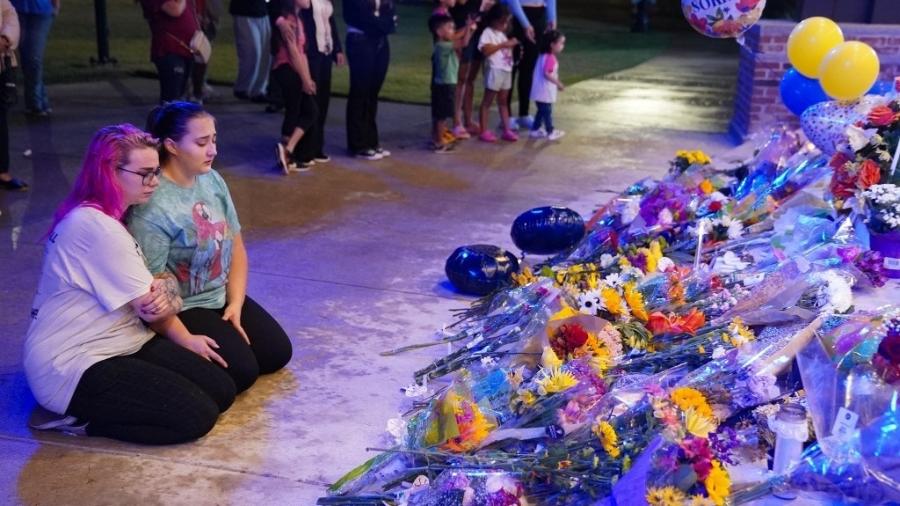 06.set.24 - Duas meninas sentam-se em frente a um memorial depois que membros da comunidade, alunos e professores da Apalachee High School se reuniram para uma vigília em Monroe, Geórgia