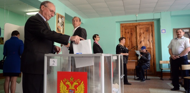 Russo deposita seu voto em urna durante processo eleitoral regional do último domingo (13). Foram escolhidos governadores e legisladores em 42 regiões do país - Dmitry Serebryakov/AFP